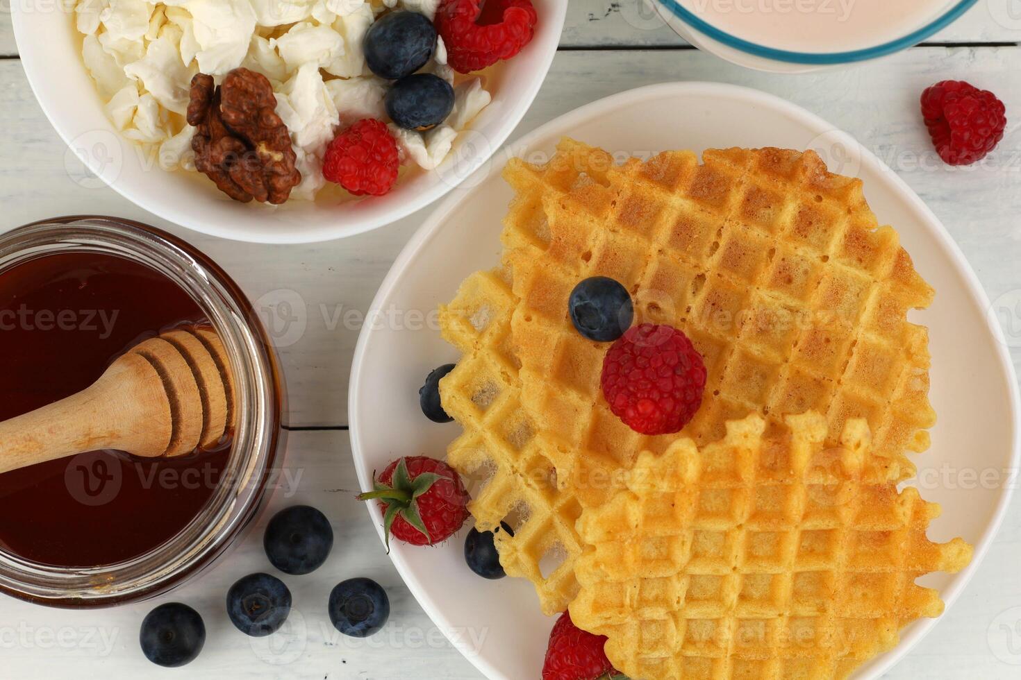 Waffles with honey and berries for breakfast photo