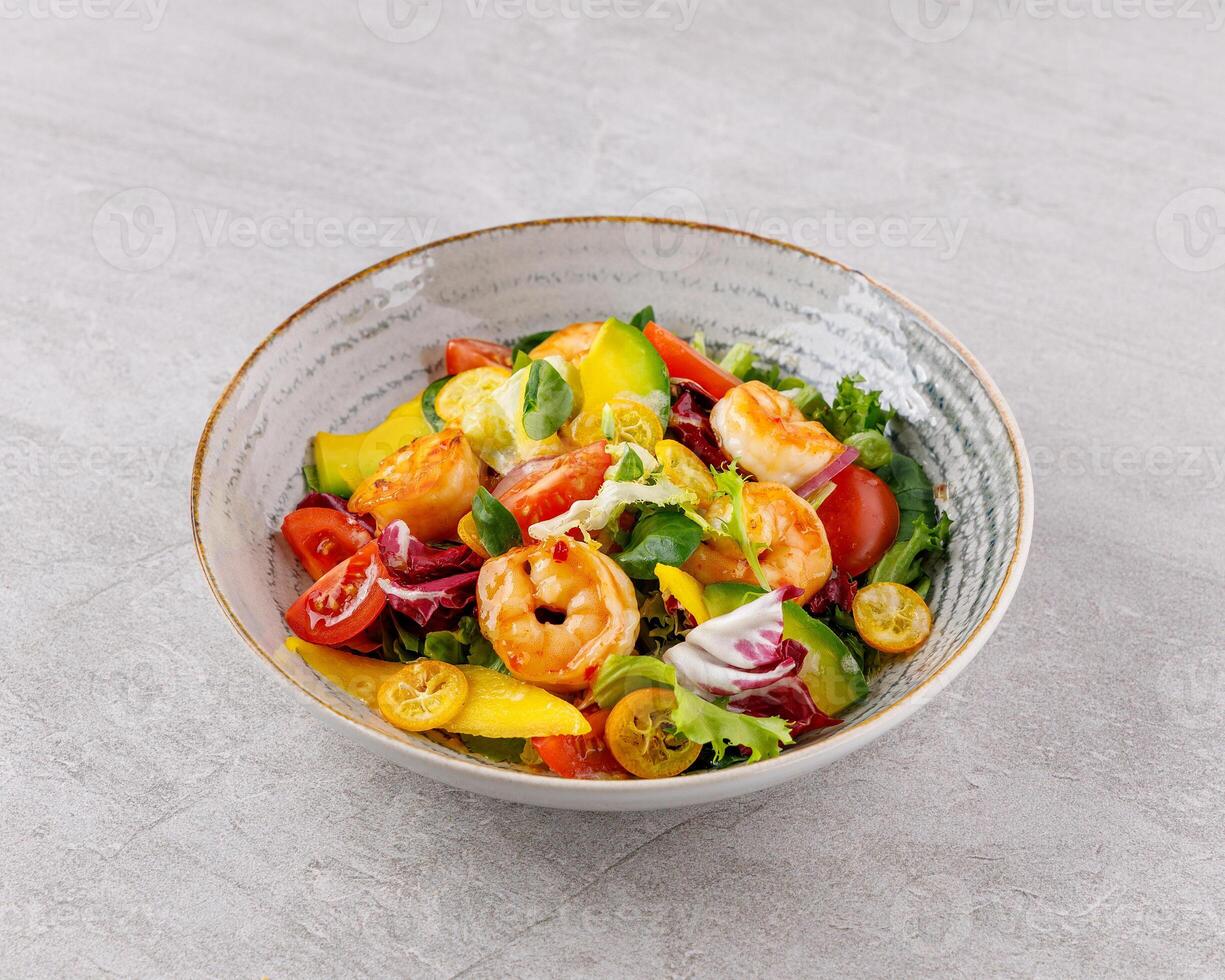 Salad with shrimps in sweet and sour sauce with mango and avocado. on a gray background photo