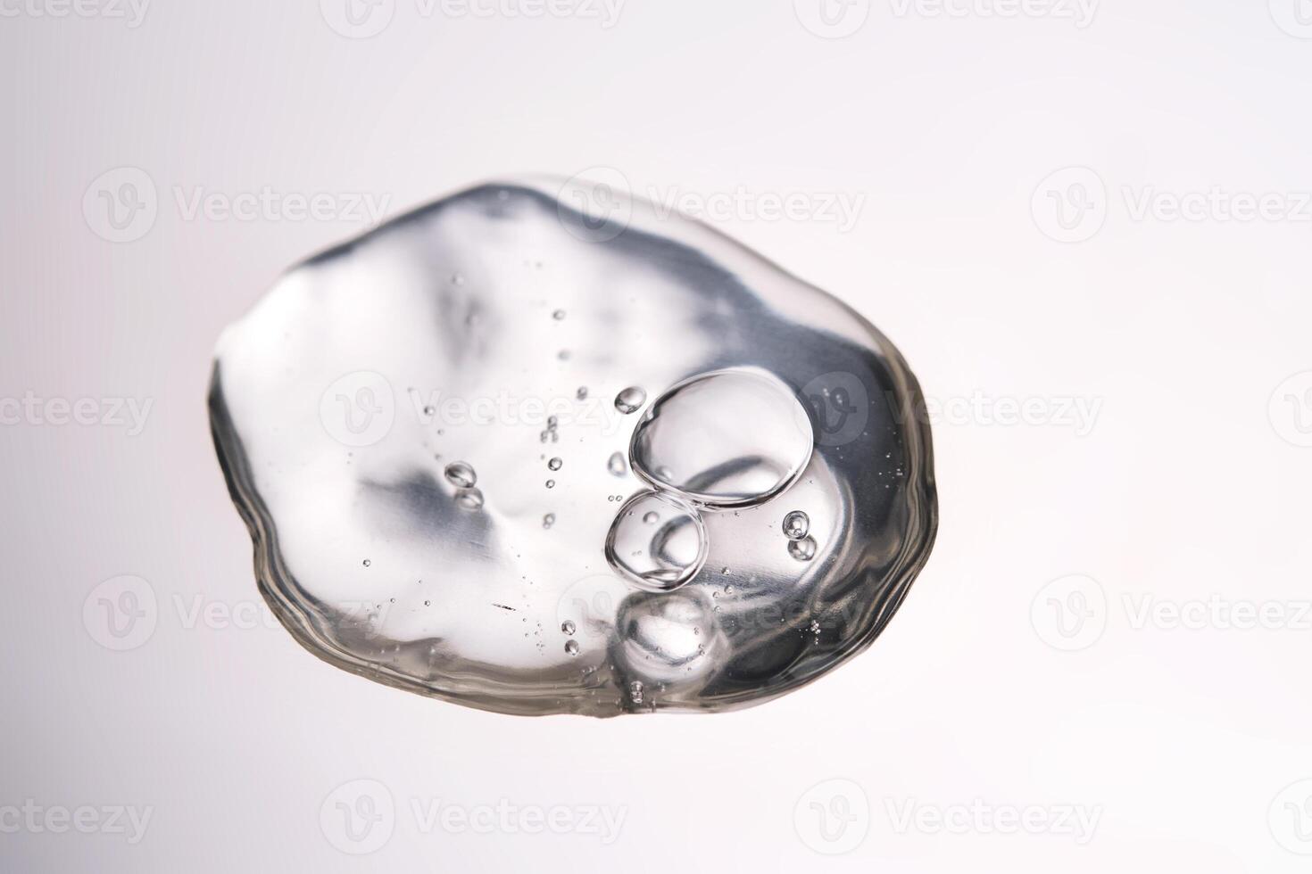 A smear of cosmetic gel close-up on a gray background. Appetizing texture with bubbles. photo