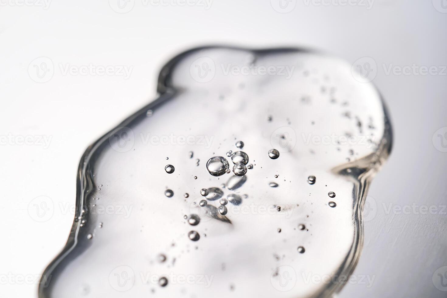 A smear of cosmetic gel close-up on a gray background. Appetizing texture with bubbles. photo