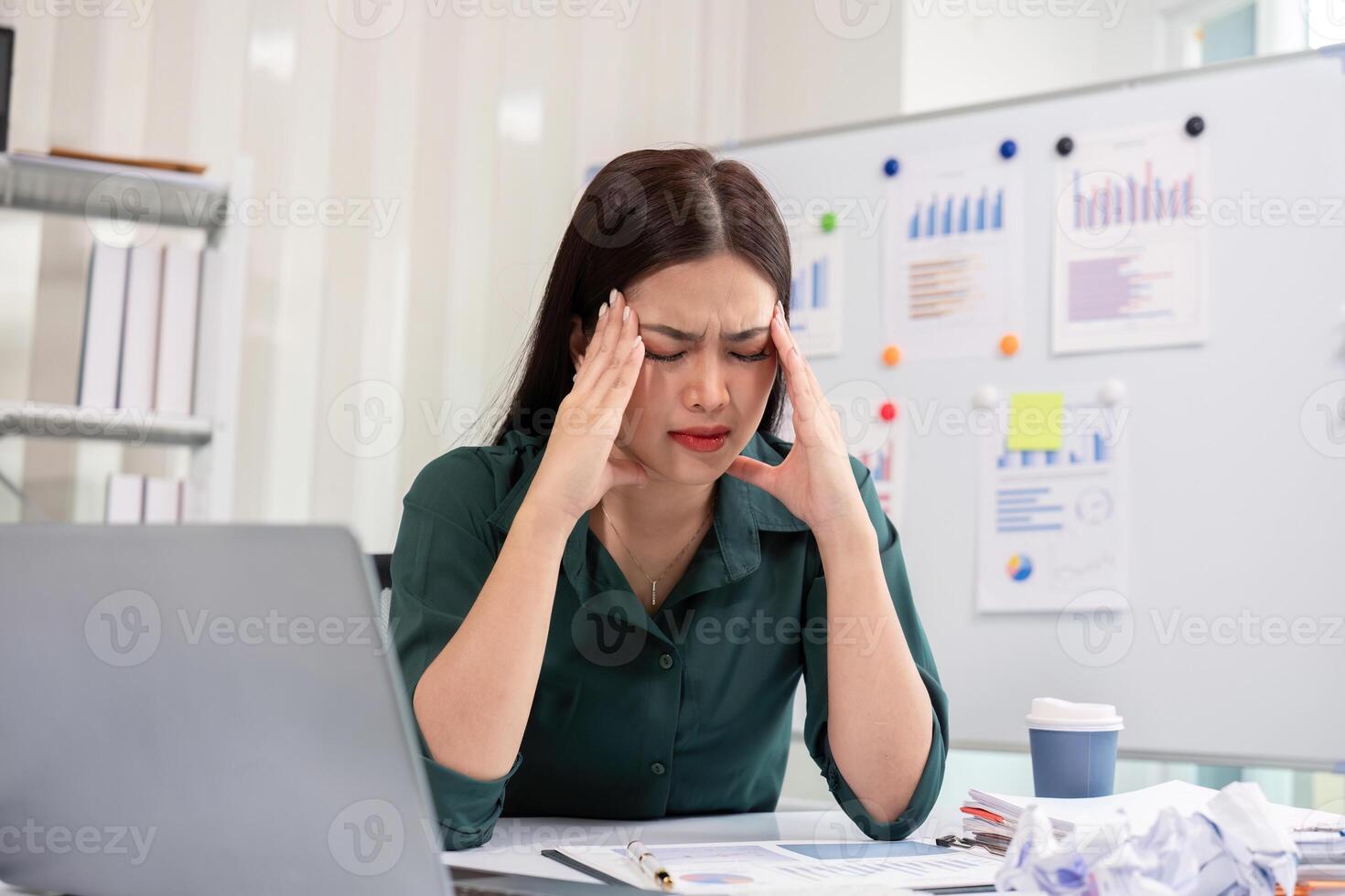 Stressed Businesswoman at Office Desk with Laptop and Documents, Experiencing Work Pressure and Fatigue photo