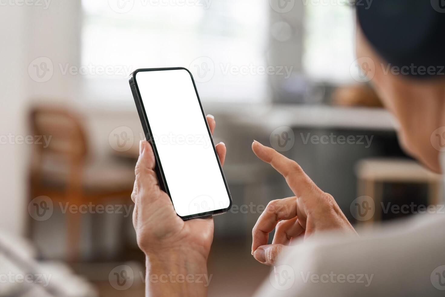 Person Using Smartphone with Blank Screen in Modern Home Office Setting photo