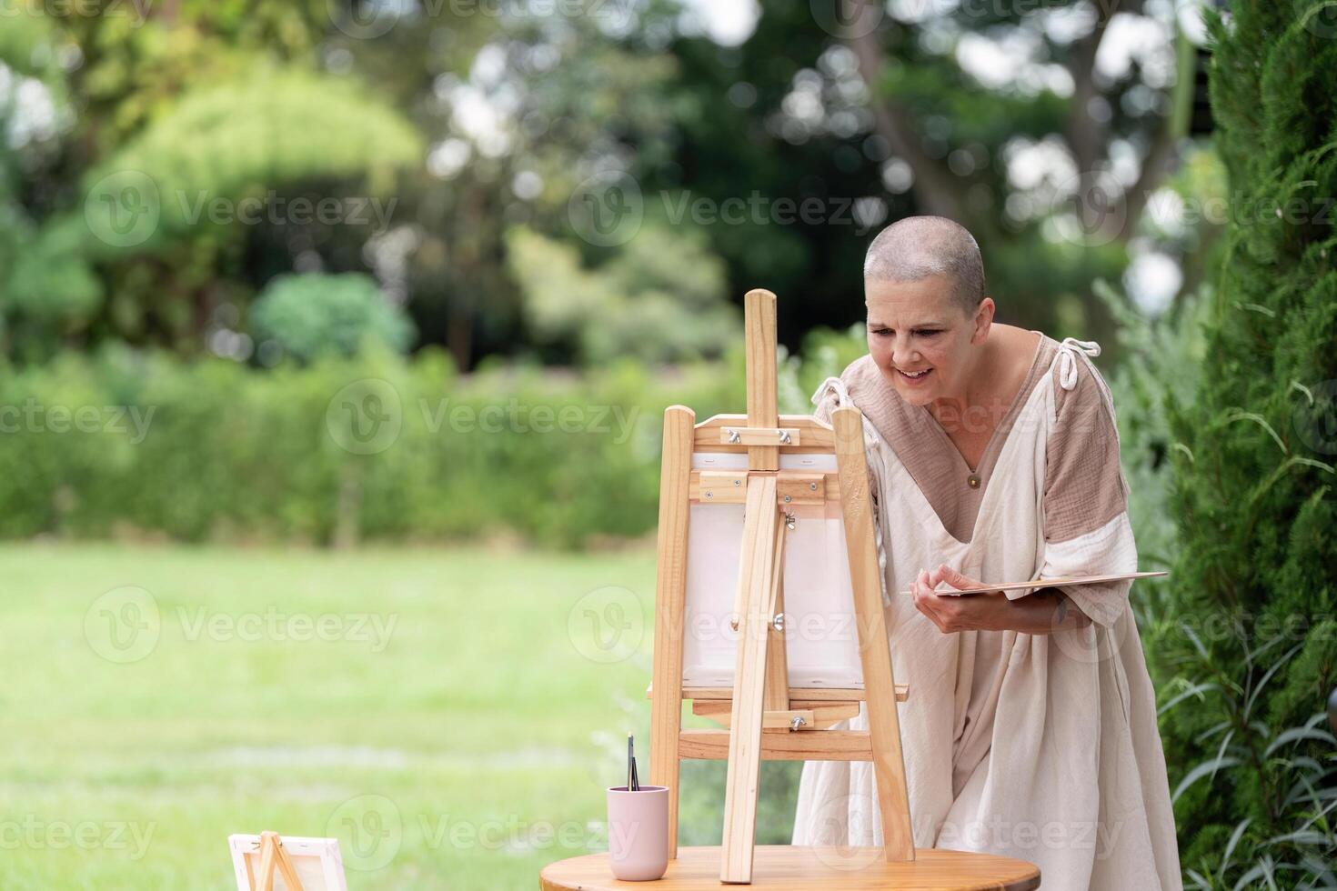 Woman Painting Outdoors on a Sunny Day with Easel and Canvas in a Green Park Setting photo