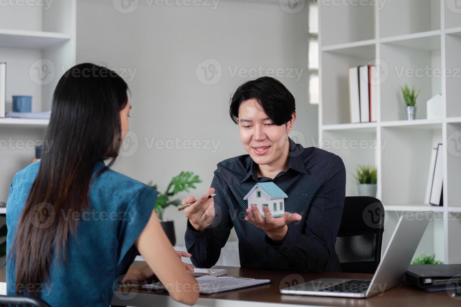 Real Estate Agent Discussing Property Details with Client in Modern Office Setting photo