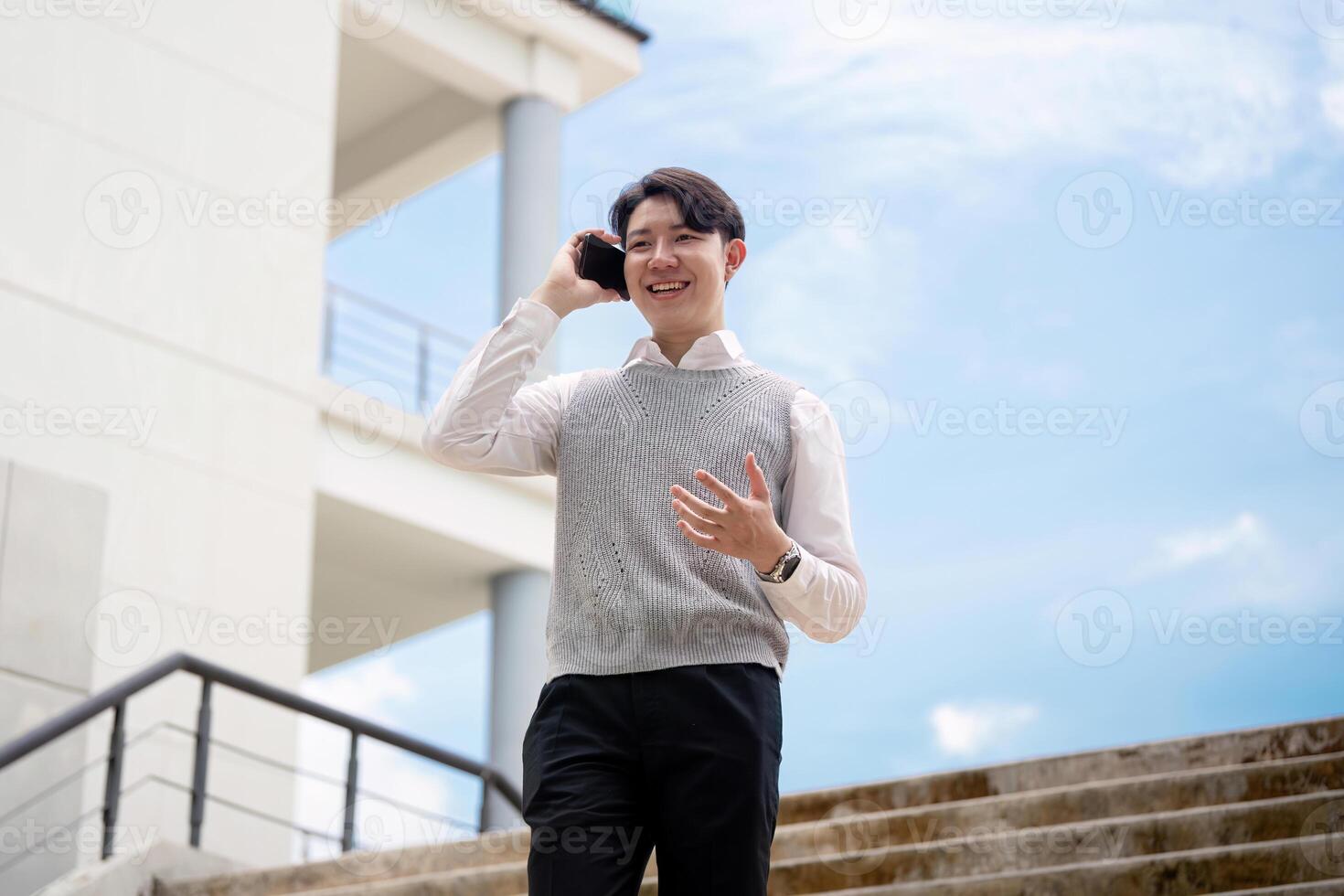 Young Professional Talking on Phone Outside Modern Office Building on a Sunny Day photo