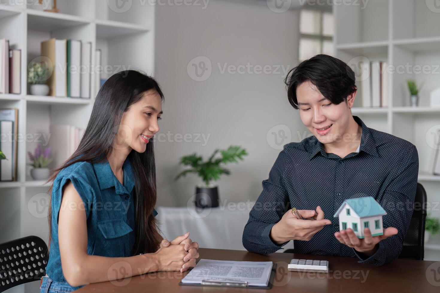 Real Estate Agent Showing Model House to Client in Modern Office Setting photo