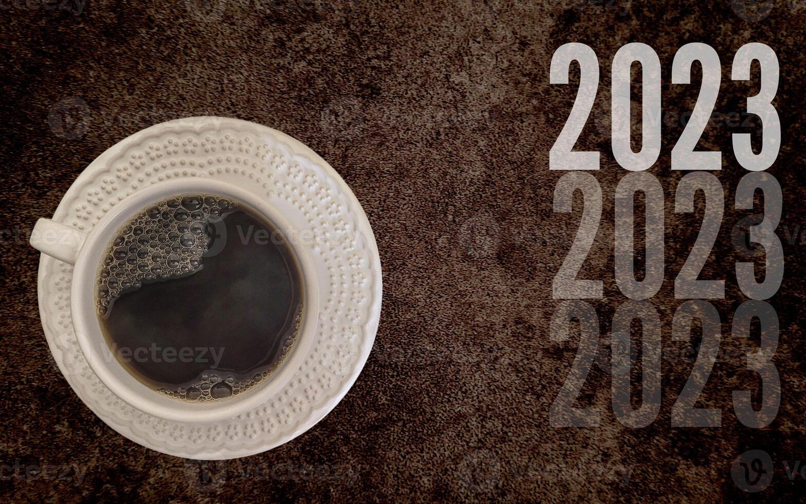 coffee with white cup with dark background written 2023, happy new year 2023 photo