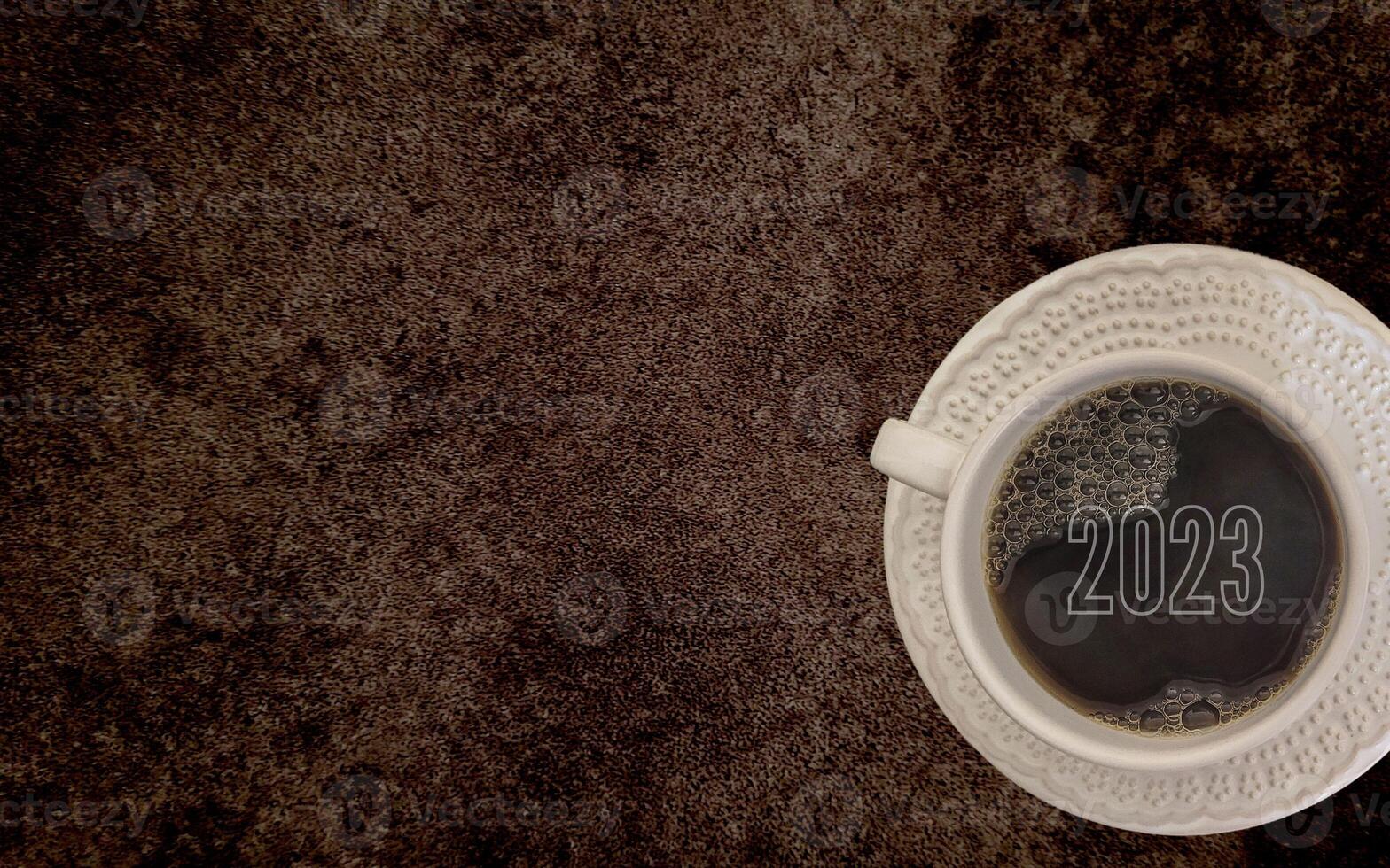 coffee with white cup with dark background written 2023, happy new year 2023 photo