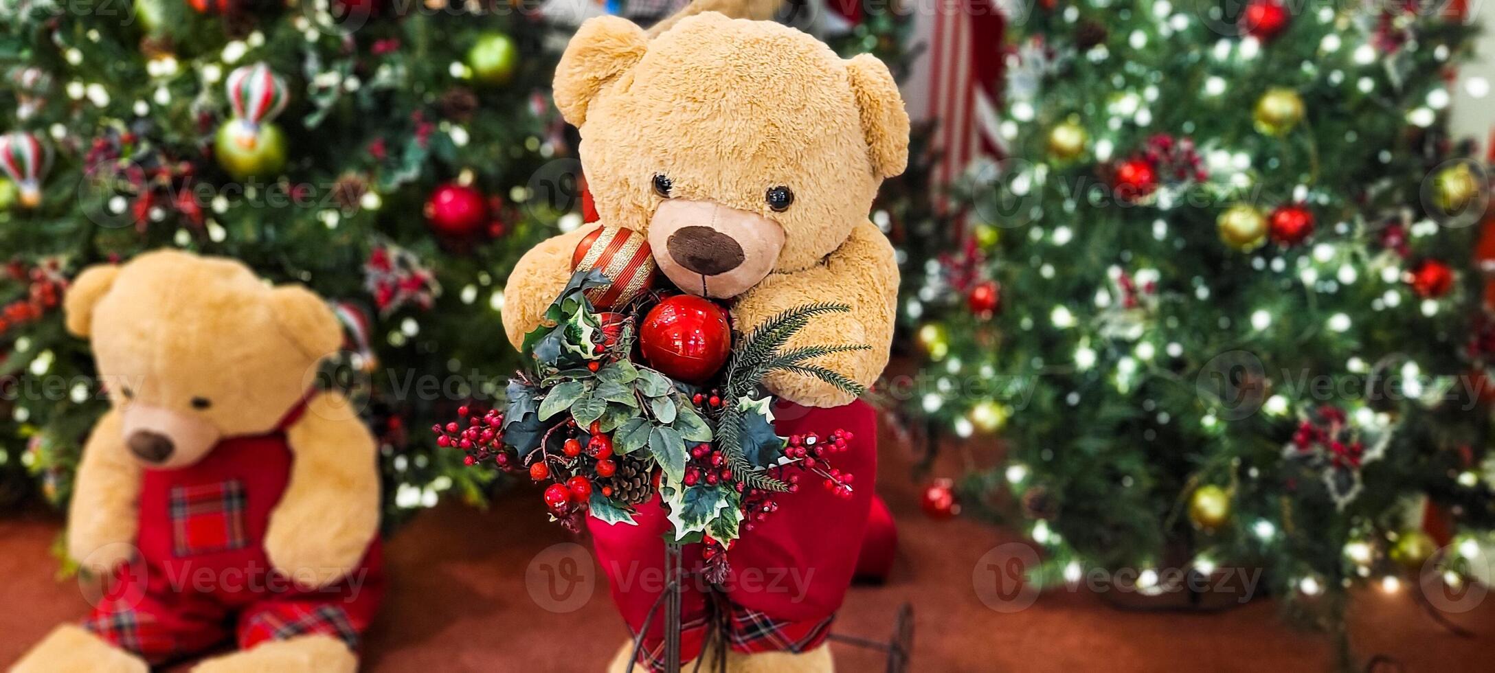 christmas tree decorated with balls and lights and christmas presents, teddy bear in christmas color, with little red bow photo
