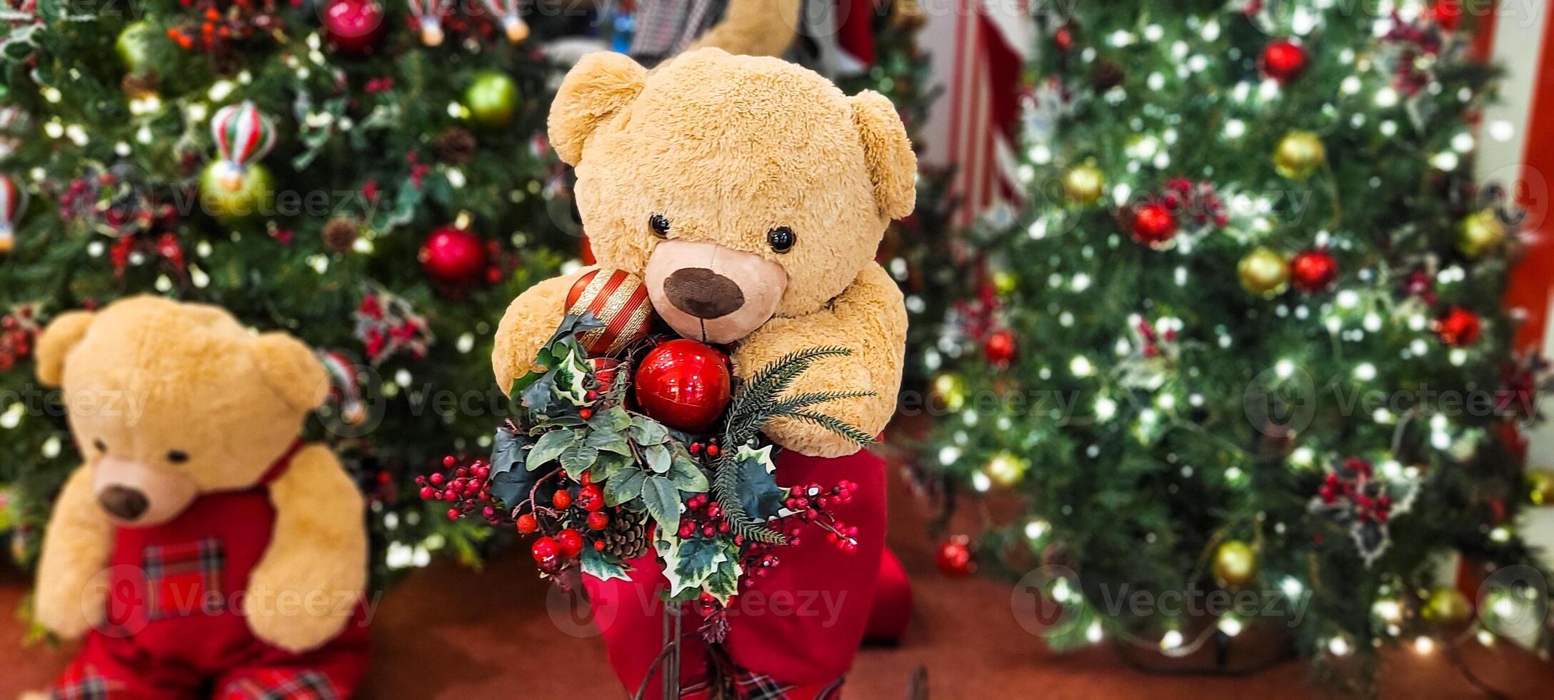 christmas tree decorated with balls and lights and christmas presents, teddy bear in christmas color, with little red bow photo