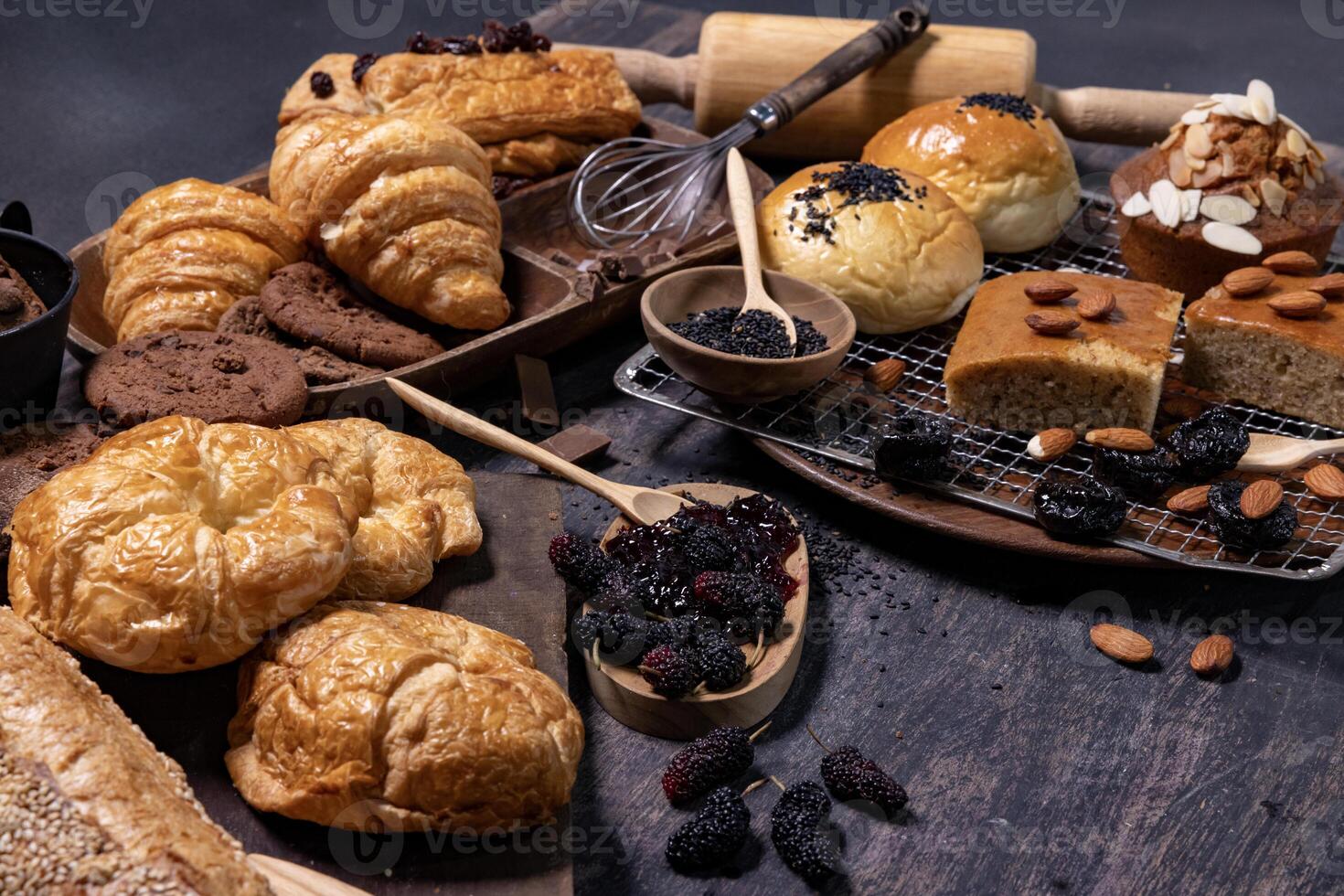 Table top view of organic rustic style bakery with whole grain bun, bread and cookies with various berry and nut for homemade healthy pastry and traditional baking bread photo