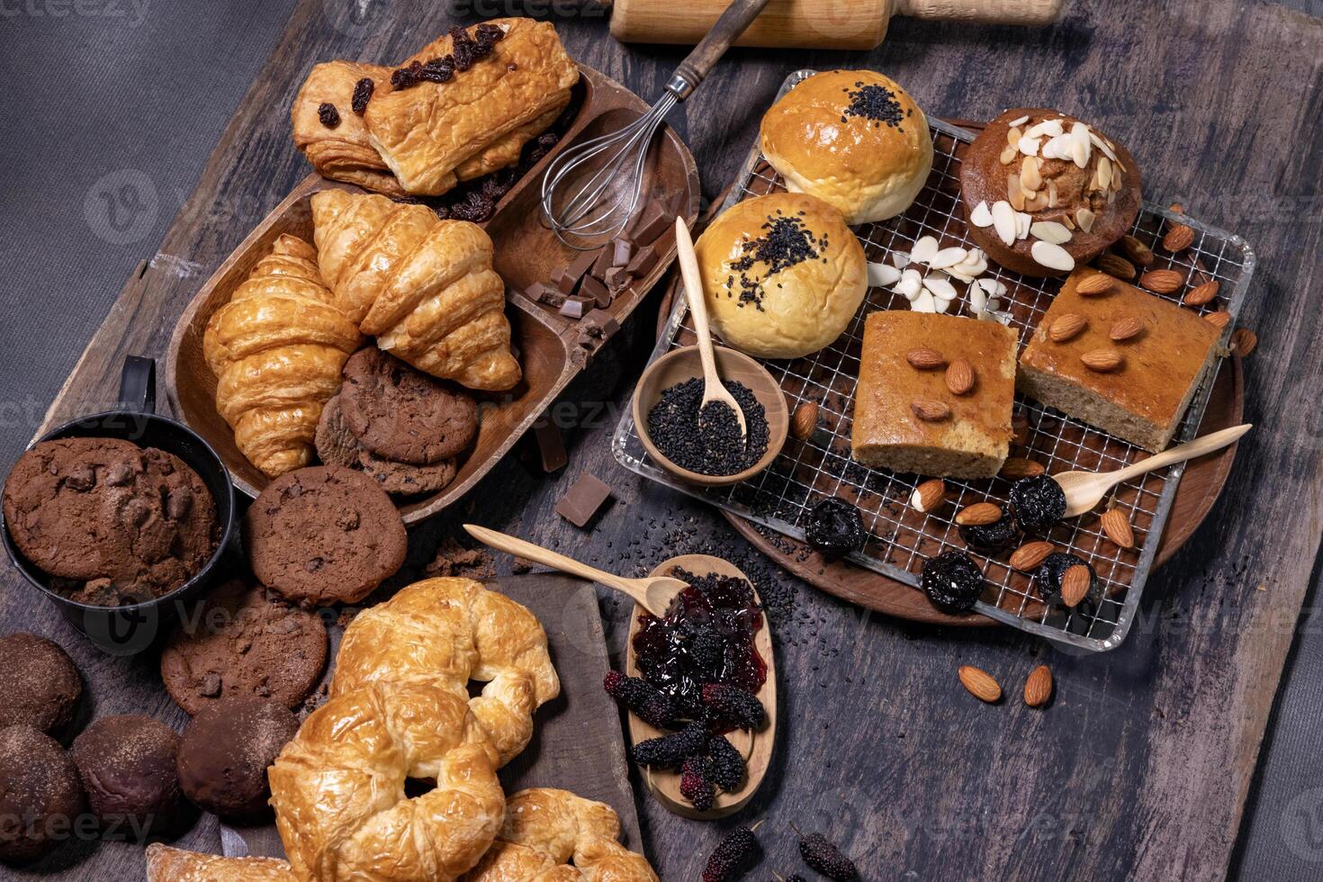 Table top view of organic rustic style bakery with whole grain bun, bread and cookies with various berry and nut for homemade healthy pastry and traditional baking bread photo