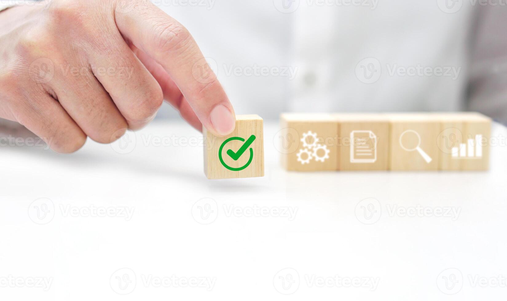 Hand holding a wooden block cube with check mark icon symbol. Business strategy, data verification and target of business. photo