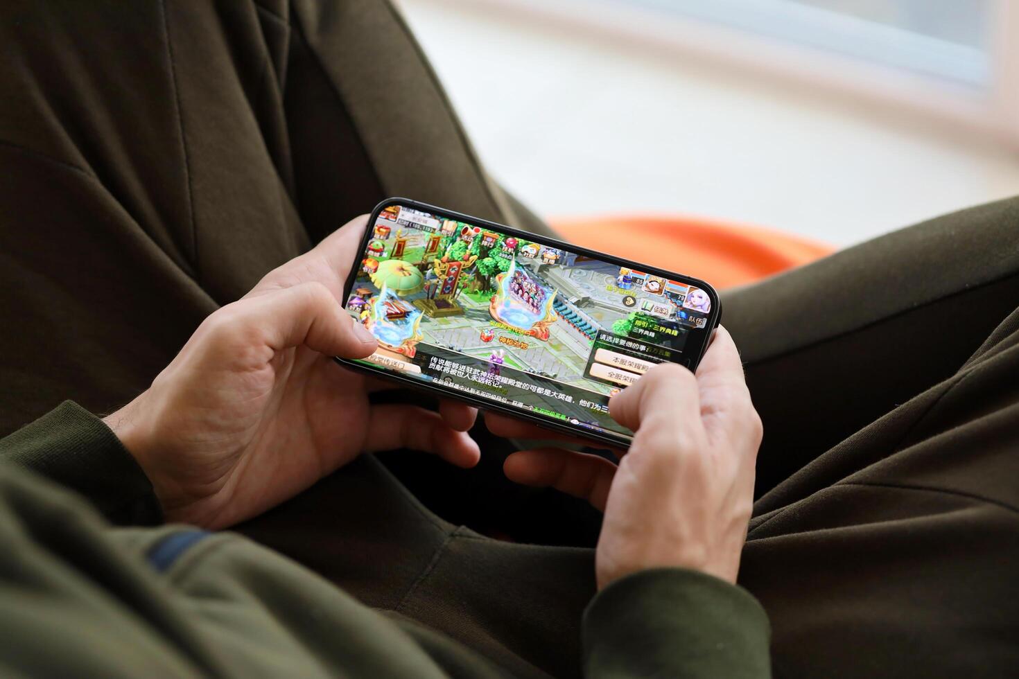 Fantasy Westward Journey mobile iOS game on iPhone 15 smartphone screen in male hands during mobile gameplay photo