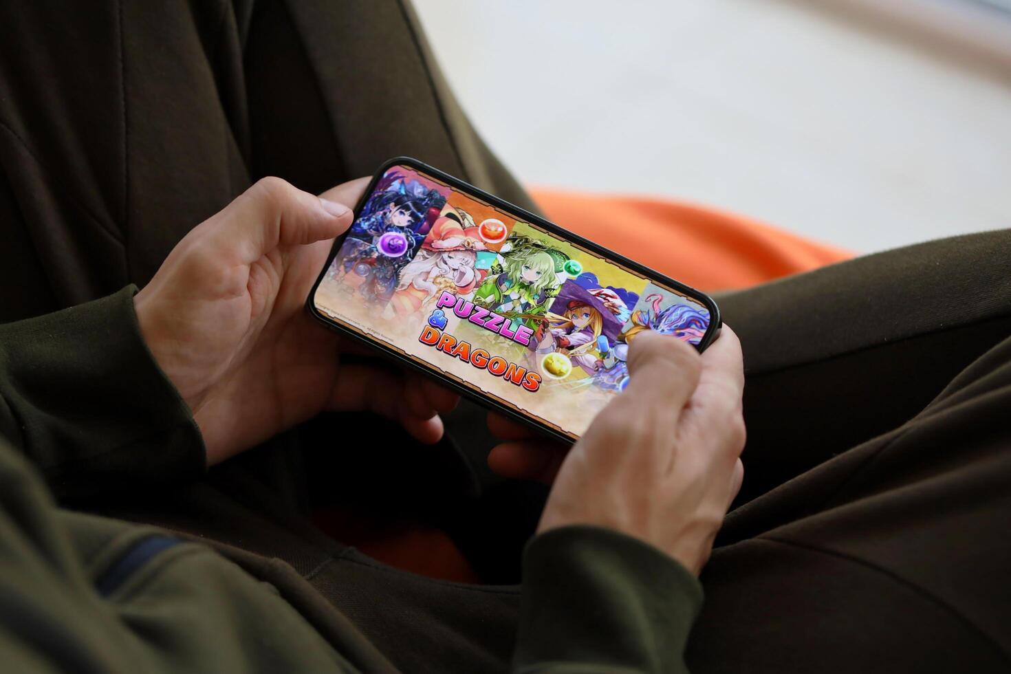 Puzzle and dragons mobile iOS game on iPhone 15 smartphone screen in male hands during mobile gameplay photo
