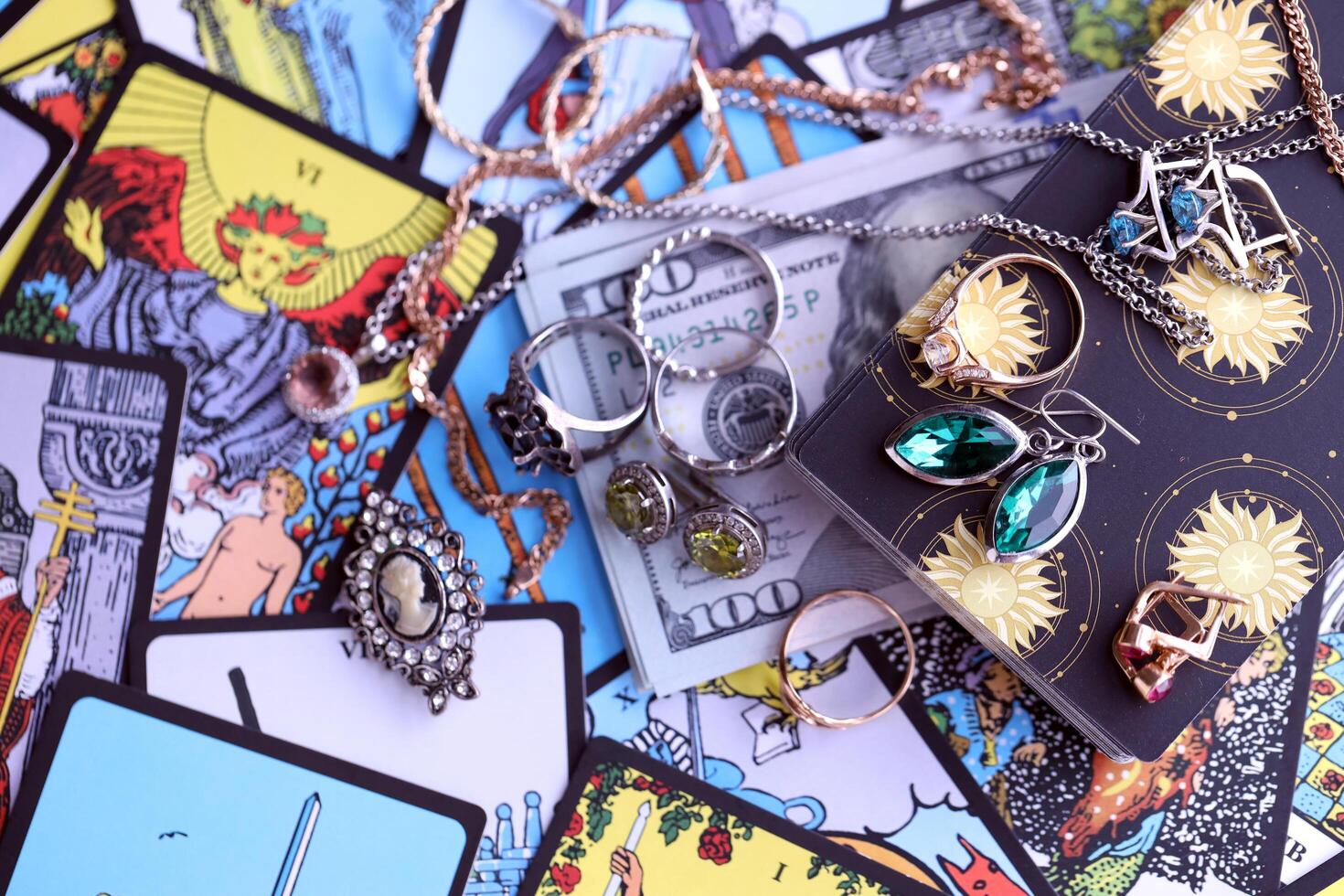 KYIV, UKRAINE - JULY 10, 2024 Tarot minor and major arcana cards of Rider Waite esoteric deck and golden rings and necklace chains. Many tarot cards for fortune telling and expensive items photo