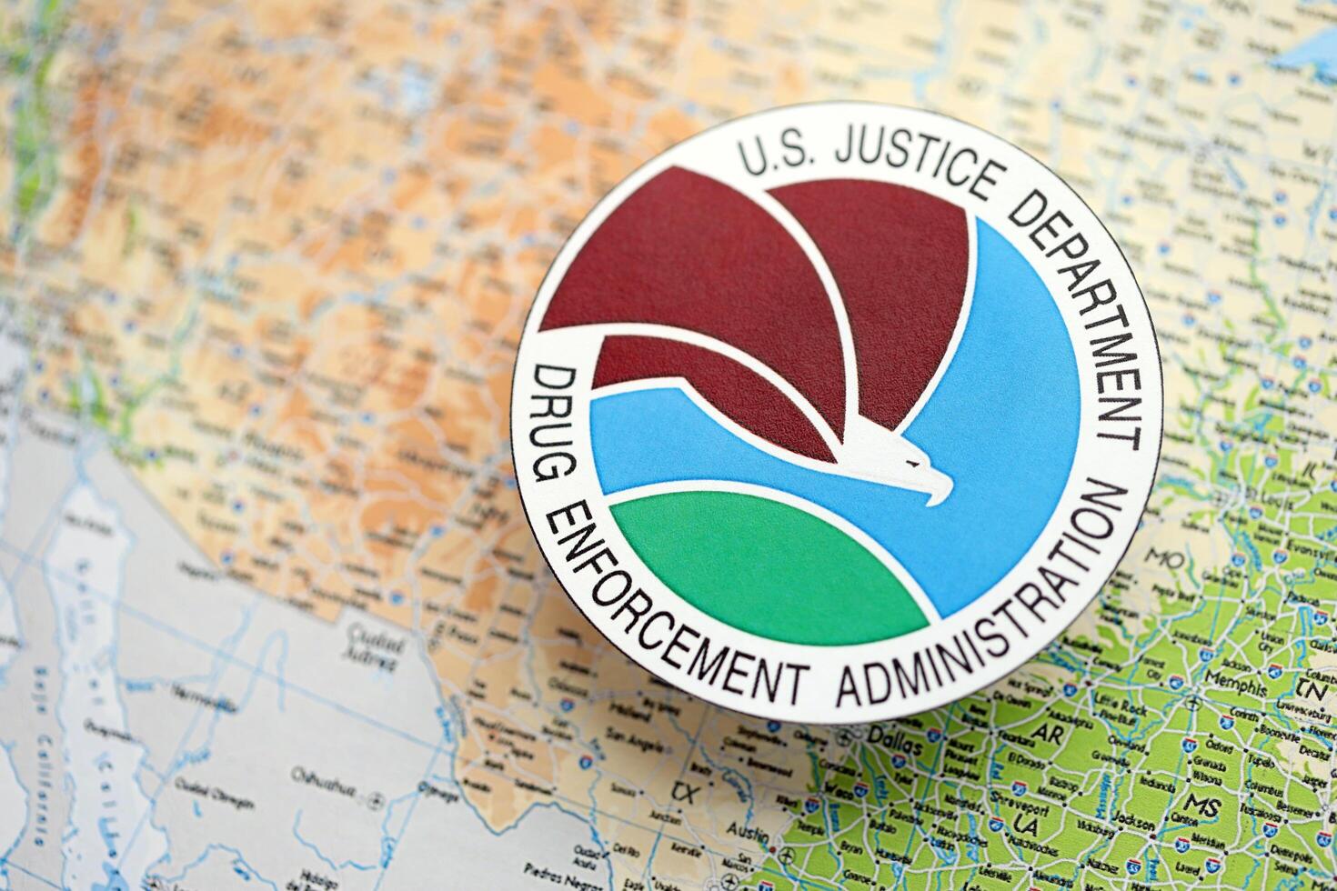 KYIV, UKRAINE - JUNE 26, 2024 U.S. Justice Department Drug Enforcement Administration coat of arms on paper map of United States photo