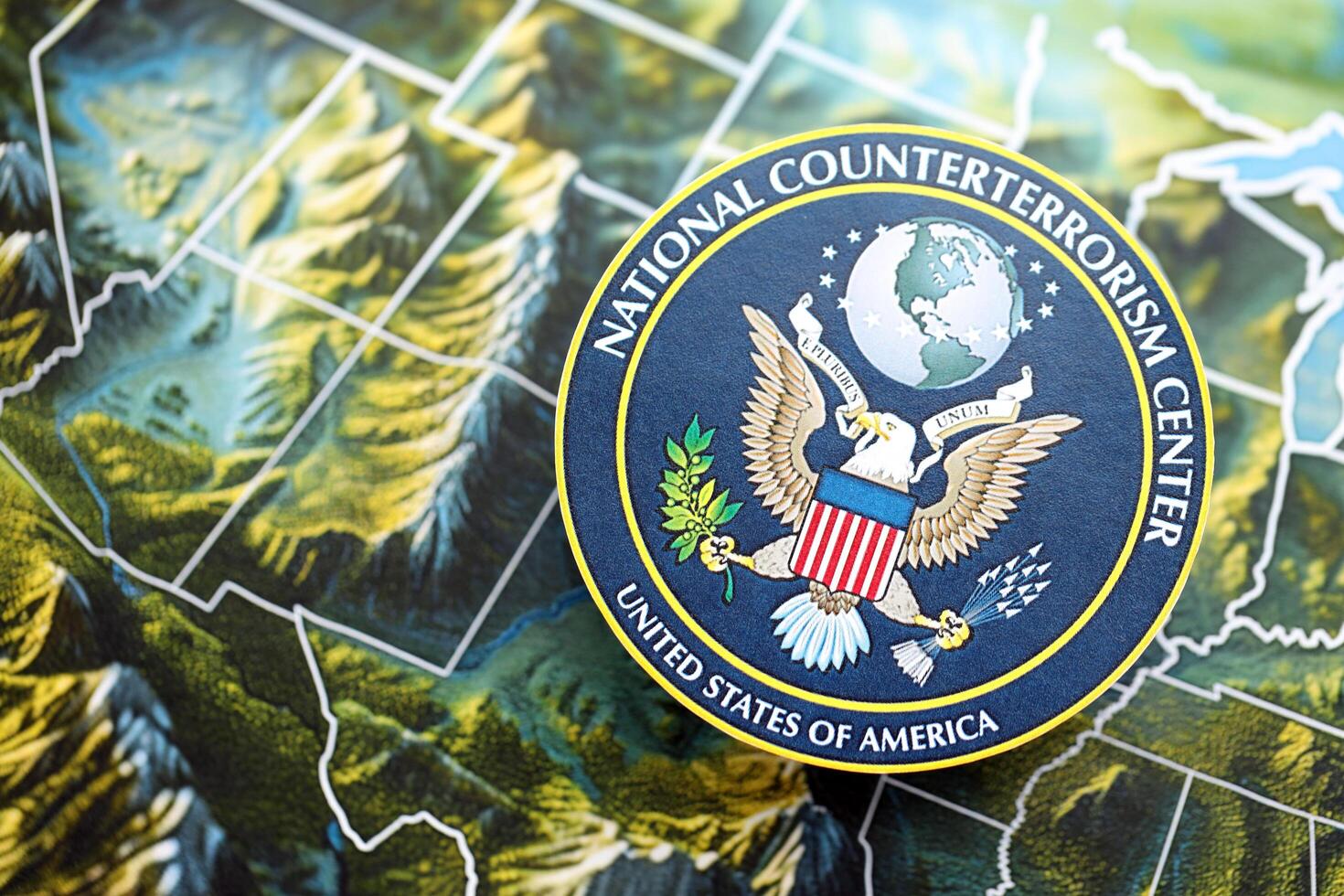 KYIV, UKRAINE - JUNE 26, 2024 United States National Counterterrorism Center coat of arms on paper map of United States photo