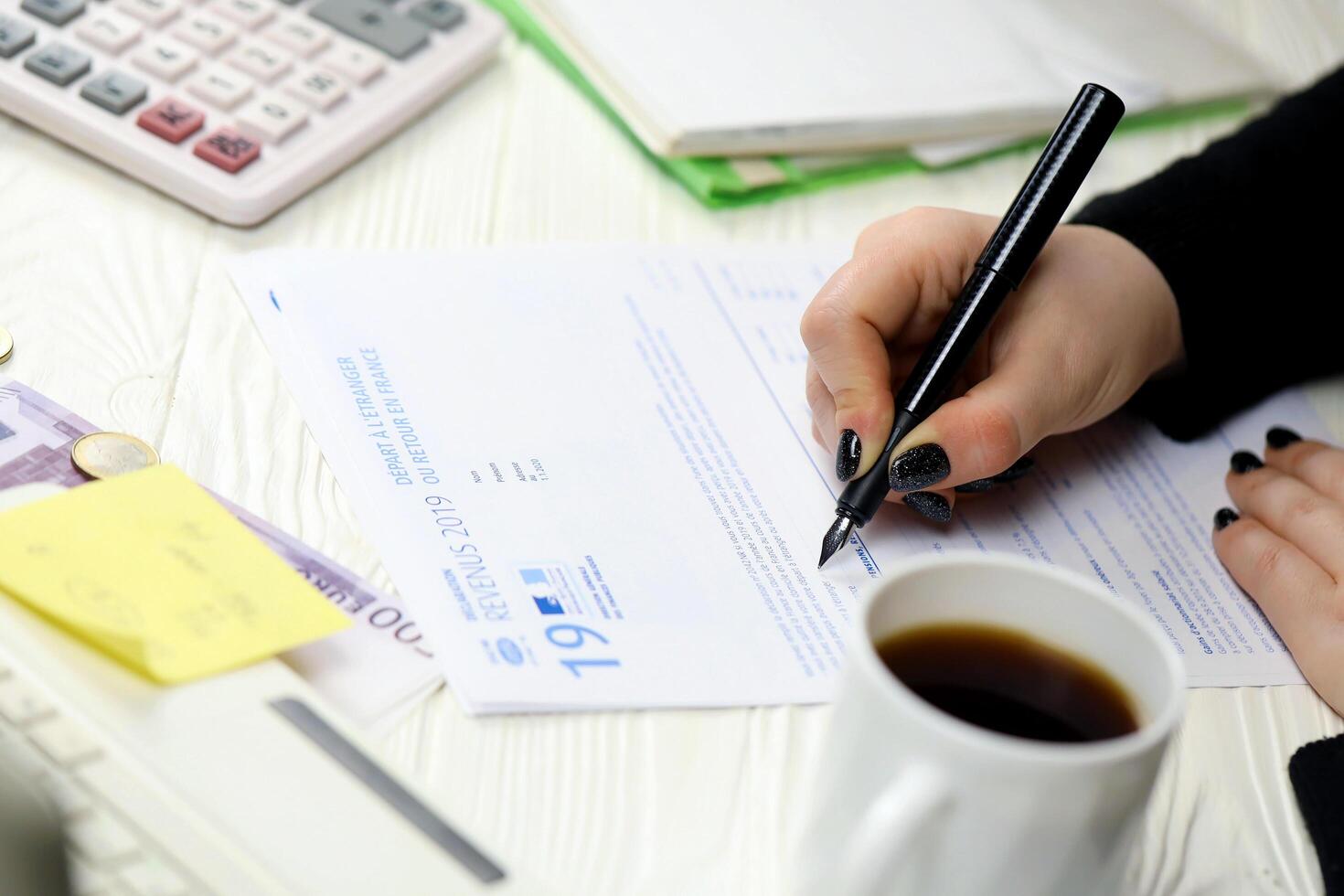 KYIV, UKRAINE - OCTOBER 31, 2023 Accountant fill french tax form 2042 NR departure abroad or return to France in end of tax period. Taxation and paperwork routine photo