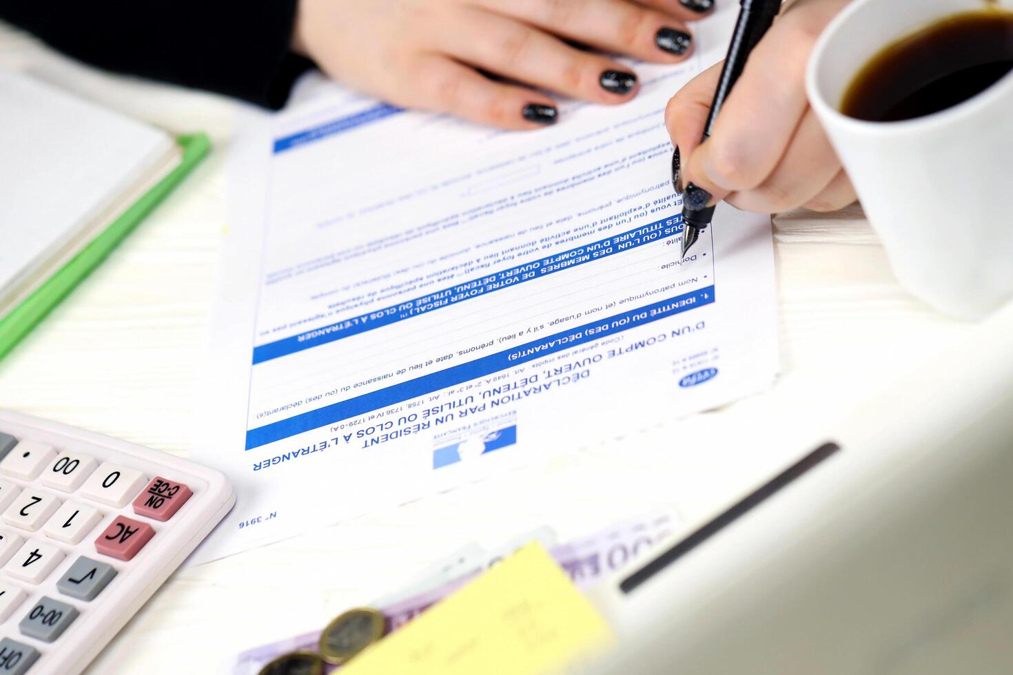 KYIV, UKRAINE - OCTOBER 31, 2023 Accountant fill french tax form 3916 Declaration by resident of account opened, held used or closed abroad in end of tax period. Taxation and paperwork photo