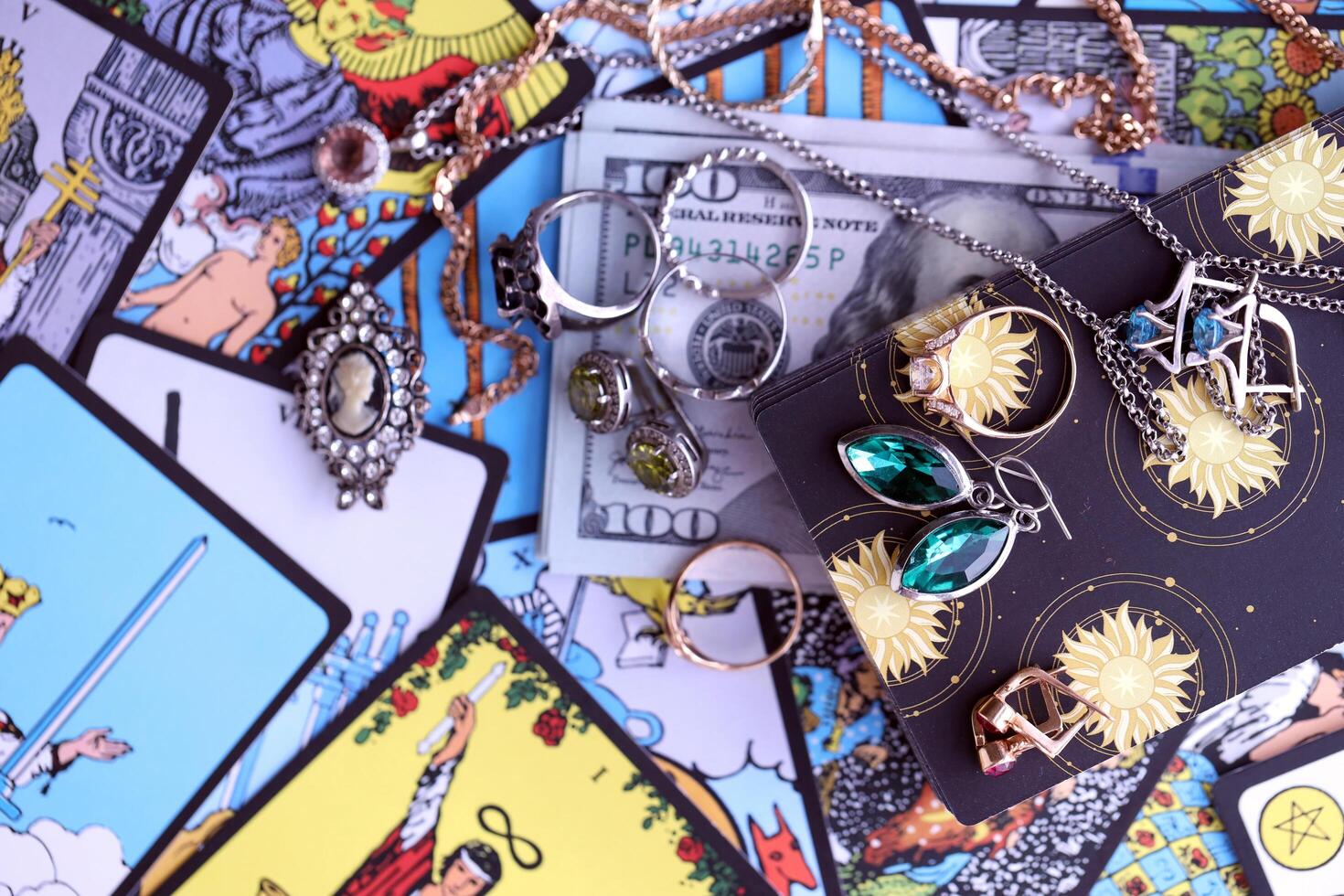 KYIV, UKRAINE - JULY 10, 2024 Tarot minor and major arcana cards of Rider Waite esoteric deck and golden rings and necklace chains. Many tarot cards for fortune telling and expensive items photo