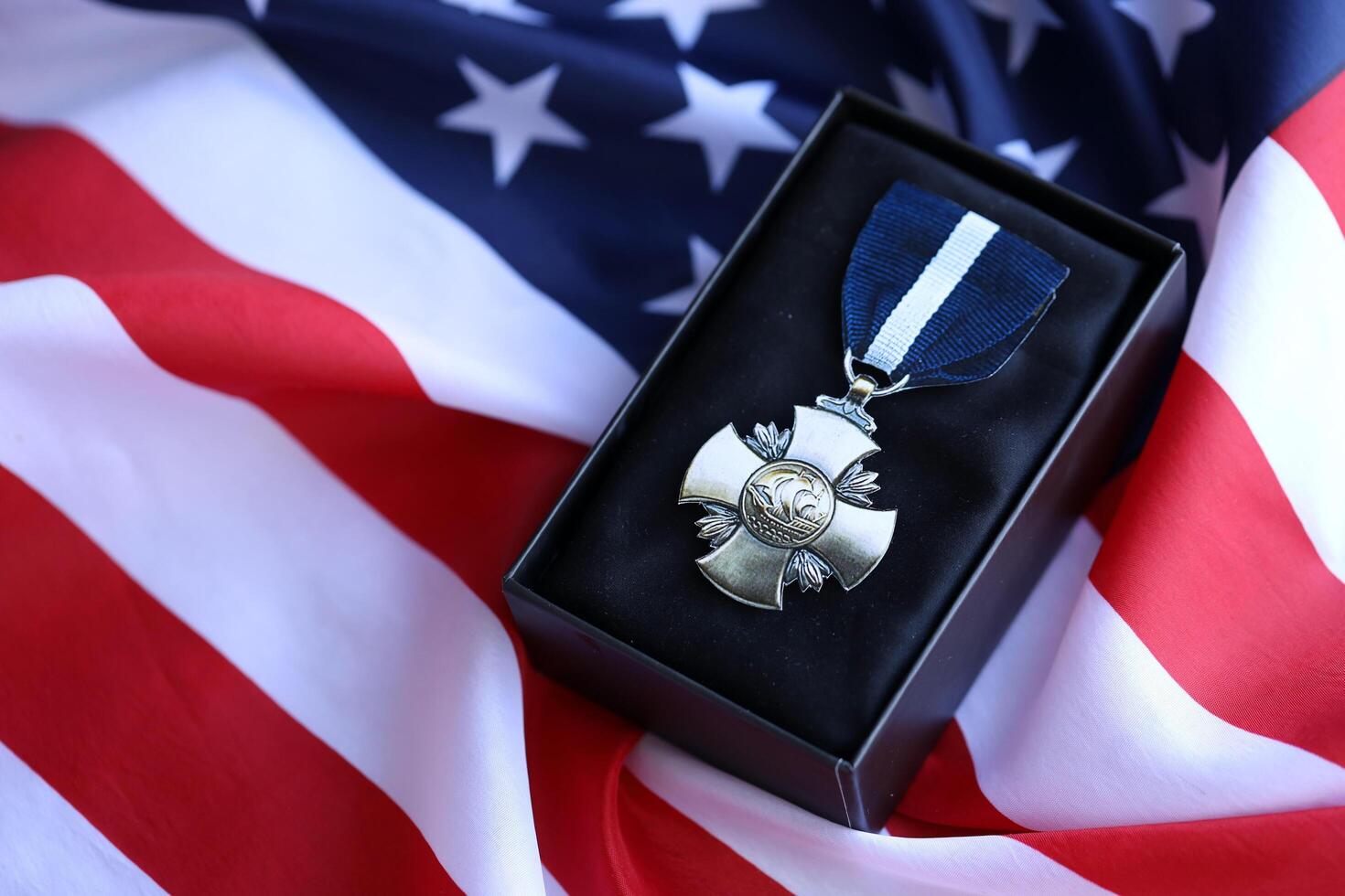 KYIV, UKRAINE - JULY 10, 2024 US Navy Cross medal. United States military award medal with ribbon and pin. Handmade paper theater props photo