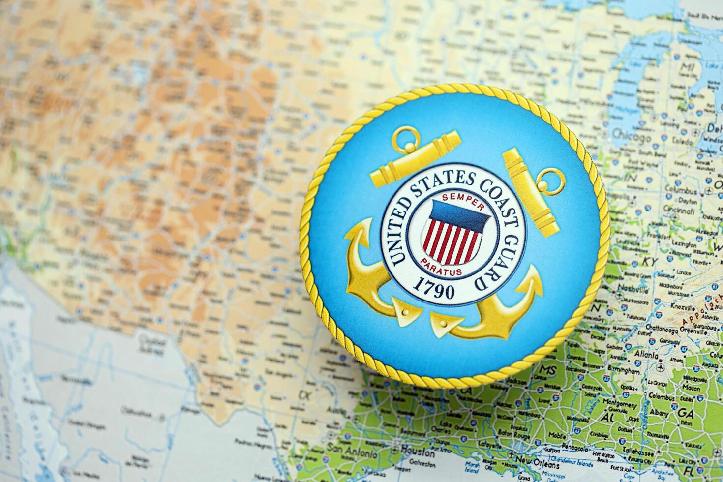 KYIV, UKRAINE - JUNE 26, 2024 United States Coast Guard coat of arms on paper map of United States photo