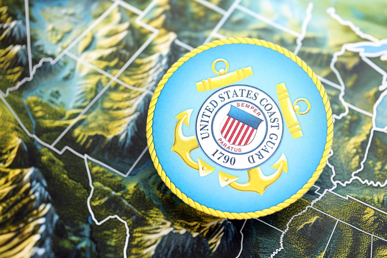 KYIV, UKRAINE - JUNE 26, 2024 United States Coast Guard coat of arms on paper map of United States photo
