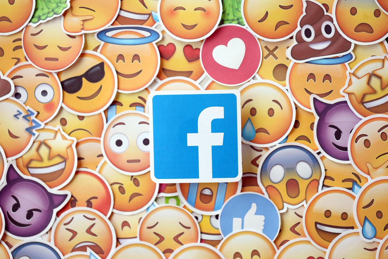 KYIV, UKRAINE - APRIL 20, 2024 Facebook logo and large set of stickers with Emoji yellow faces. Emoji is a pictogram or smiley embedded in text and used in electronic messages photo