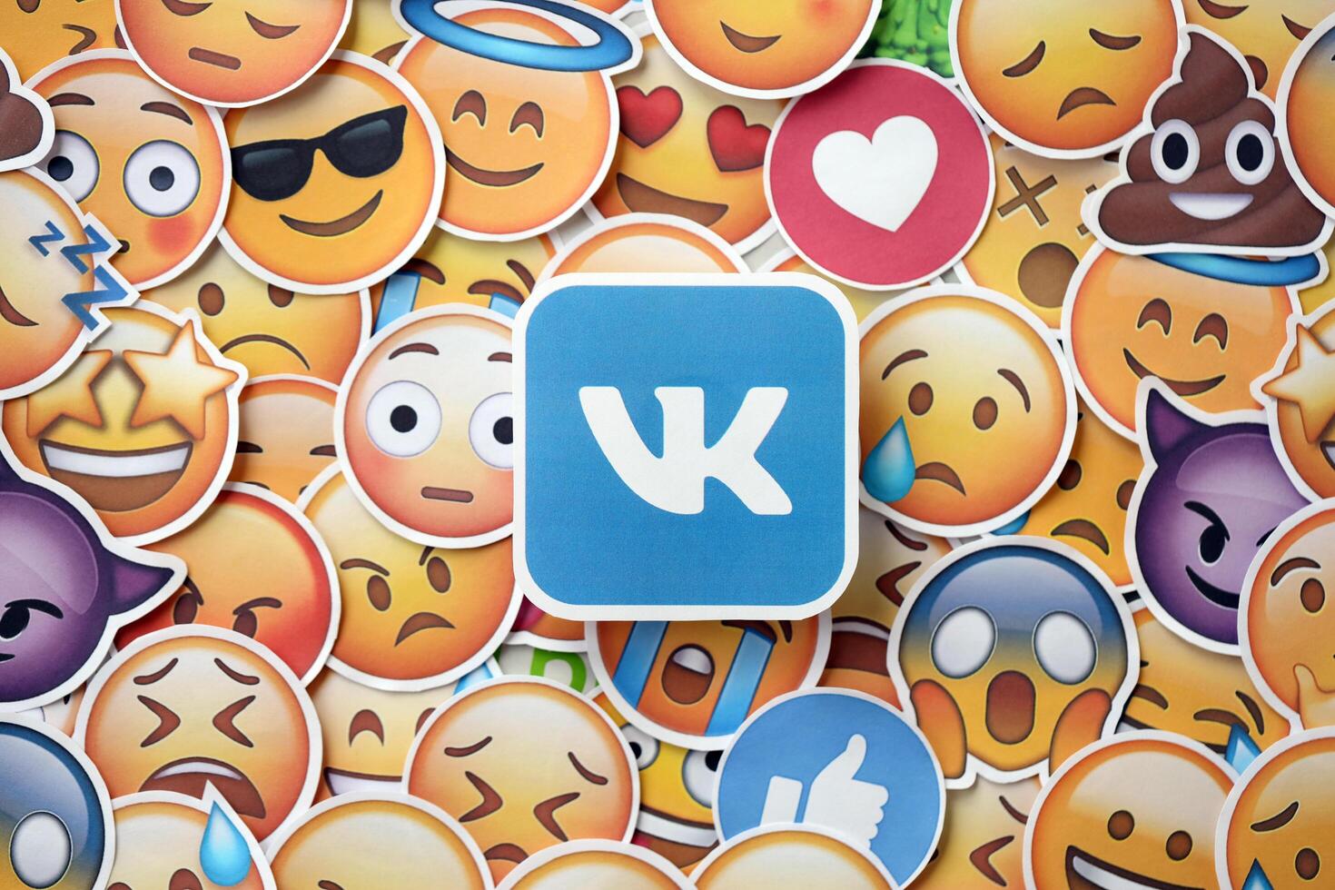 KYIV, UKRAINE - APRIL 20, 2024 VK logo and large set of stickers with Emoji yellow faces. Emoji is a pictogram or smiley embedded in text and used in electronic messages photo