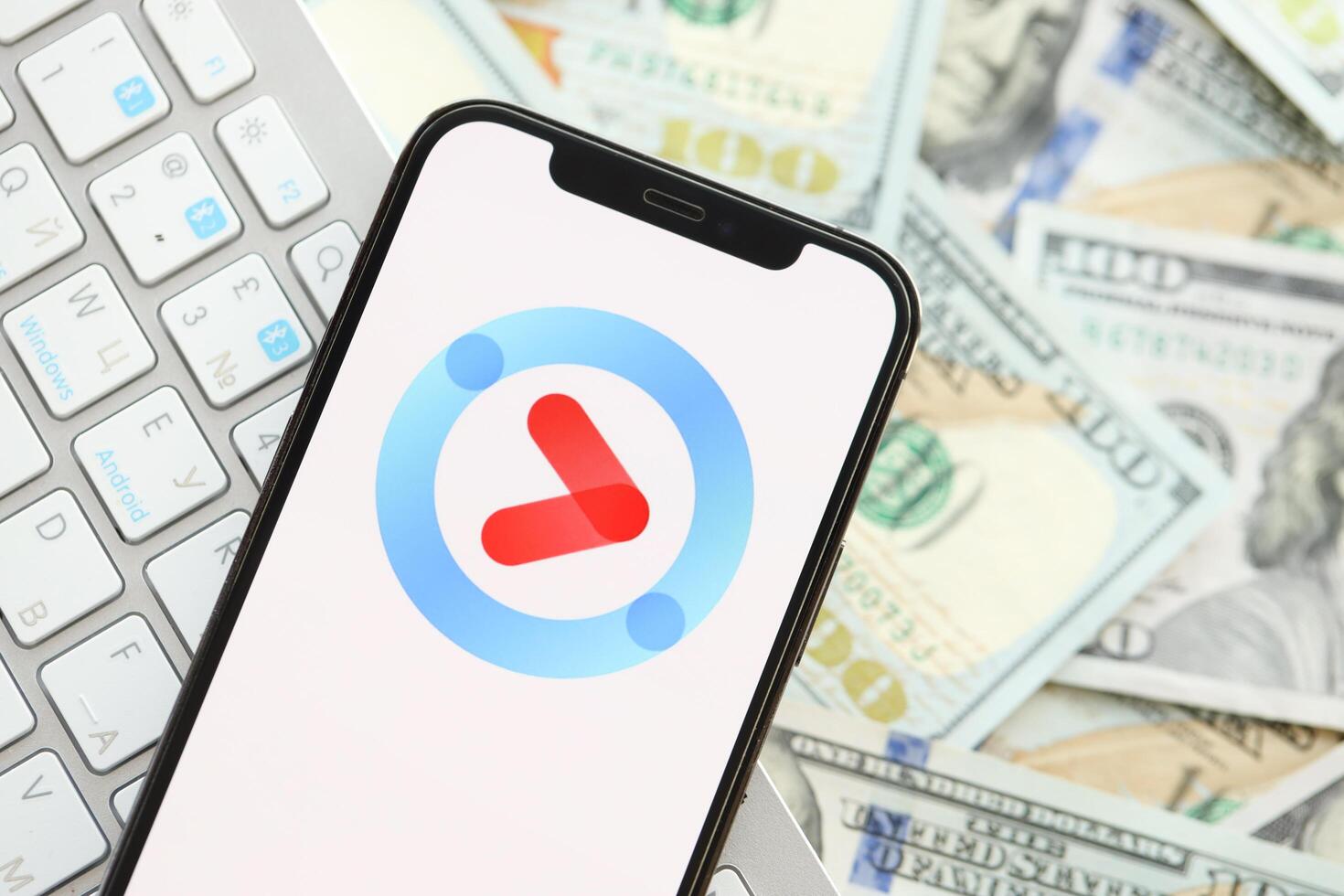 KYIV, UKRAINE - APRIL 1, 2024 Youku icon on smartphone screen on many usd money bills photo