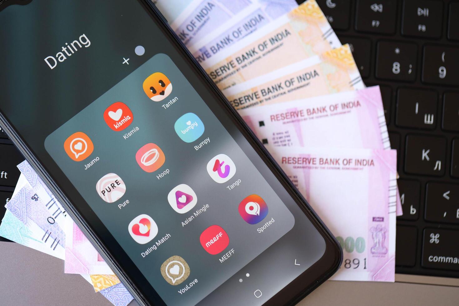KYIV, UKRAINE - FEBRUARY 28, 2024 Dating apps icons on smartphone display and Indian rupees money photo
