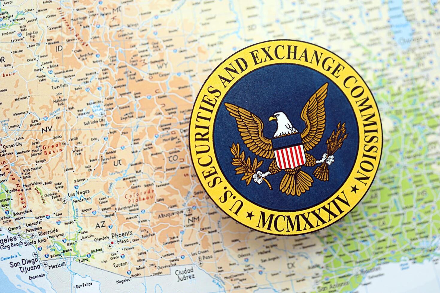KYIV, UKRAINE - JUNE 26, 2024 U.S. Securities and Exchange Commission coat of arms on paper map of United States photo