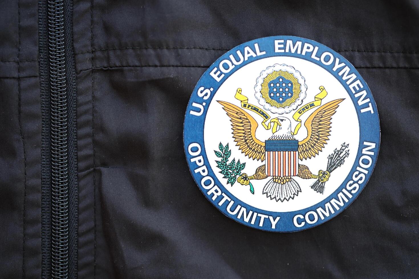 KYIV, UKRAINE - JUNE 26, 2024 U.S. Equal Employment Opportunity Commission coat of arms as pin on black uniform jacket photo