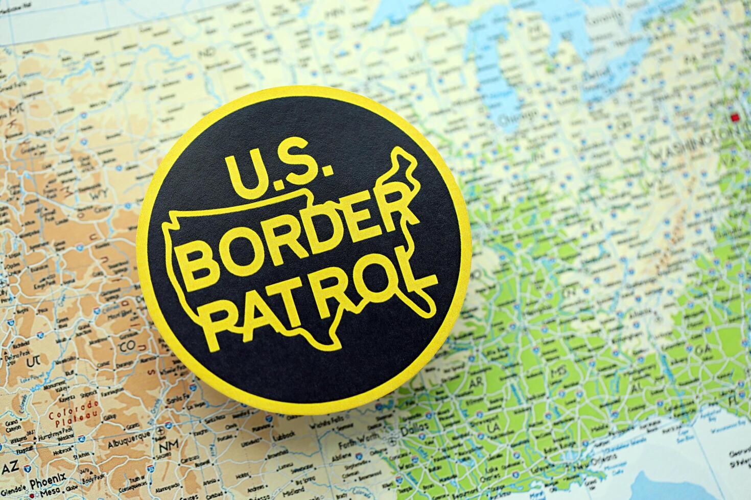 KYIV, UKRAINE - JUNE 26, 2024 U.S. Border Patrol coat of arms on paper map of United States photo