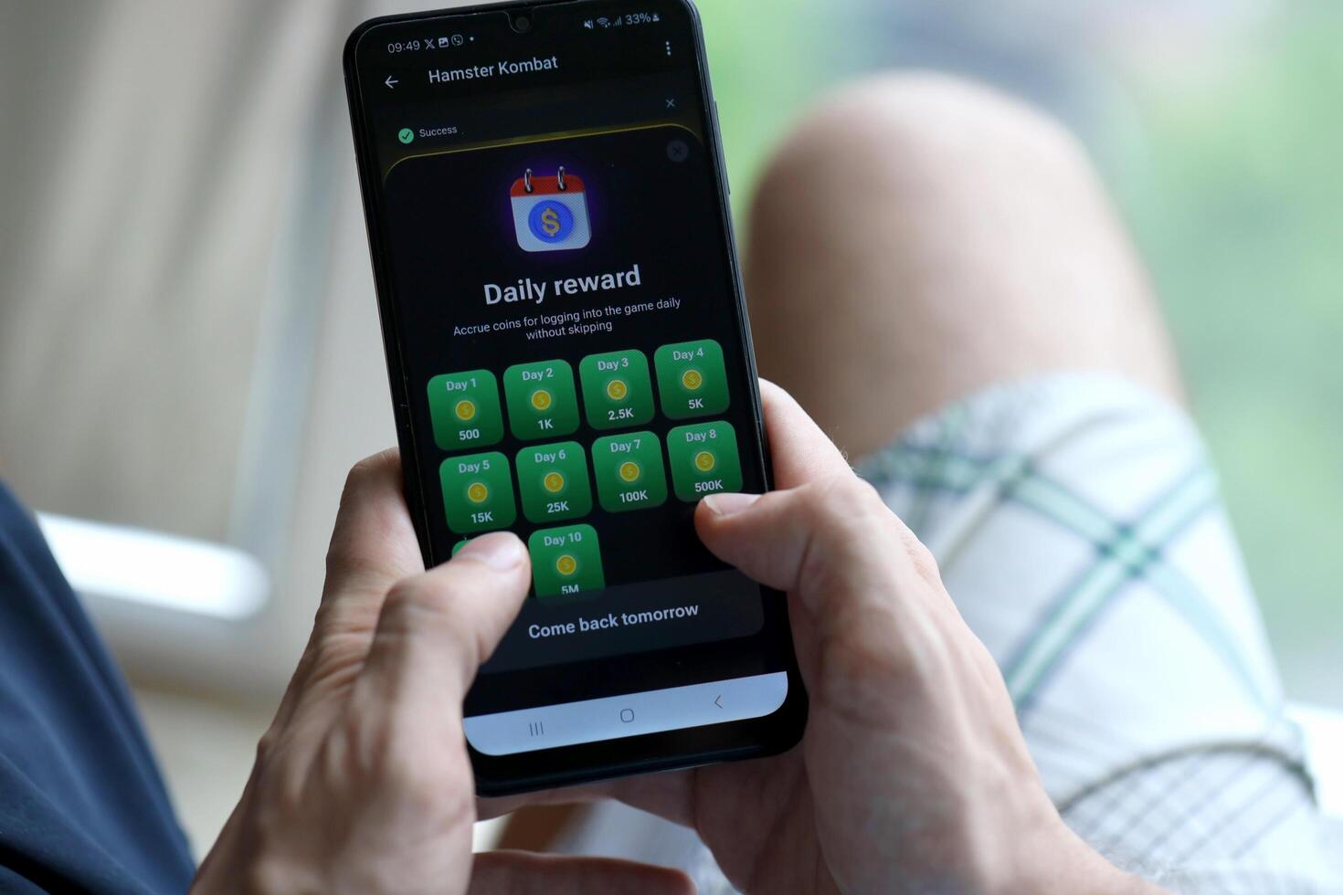 KYIV, UKRAINE - APRIL 20, 2024 Hamster Kombat telegram bot on smartphone screen. Hamster Kombat is a viral Telegram crypto game for earn HMSTR tokens by managing virtual crypto exchange photo