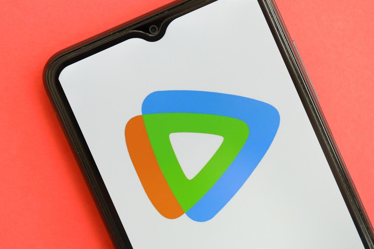 KYIV, UKRAINE - APRIL 1, 2024 Tencent WeTV icon on smartphone screen on red table photo