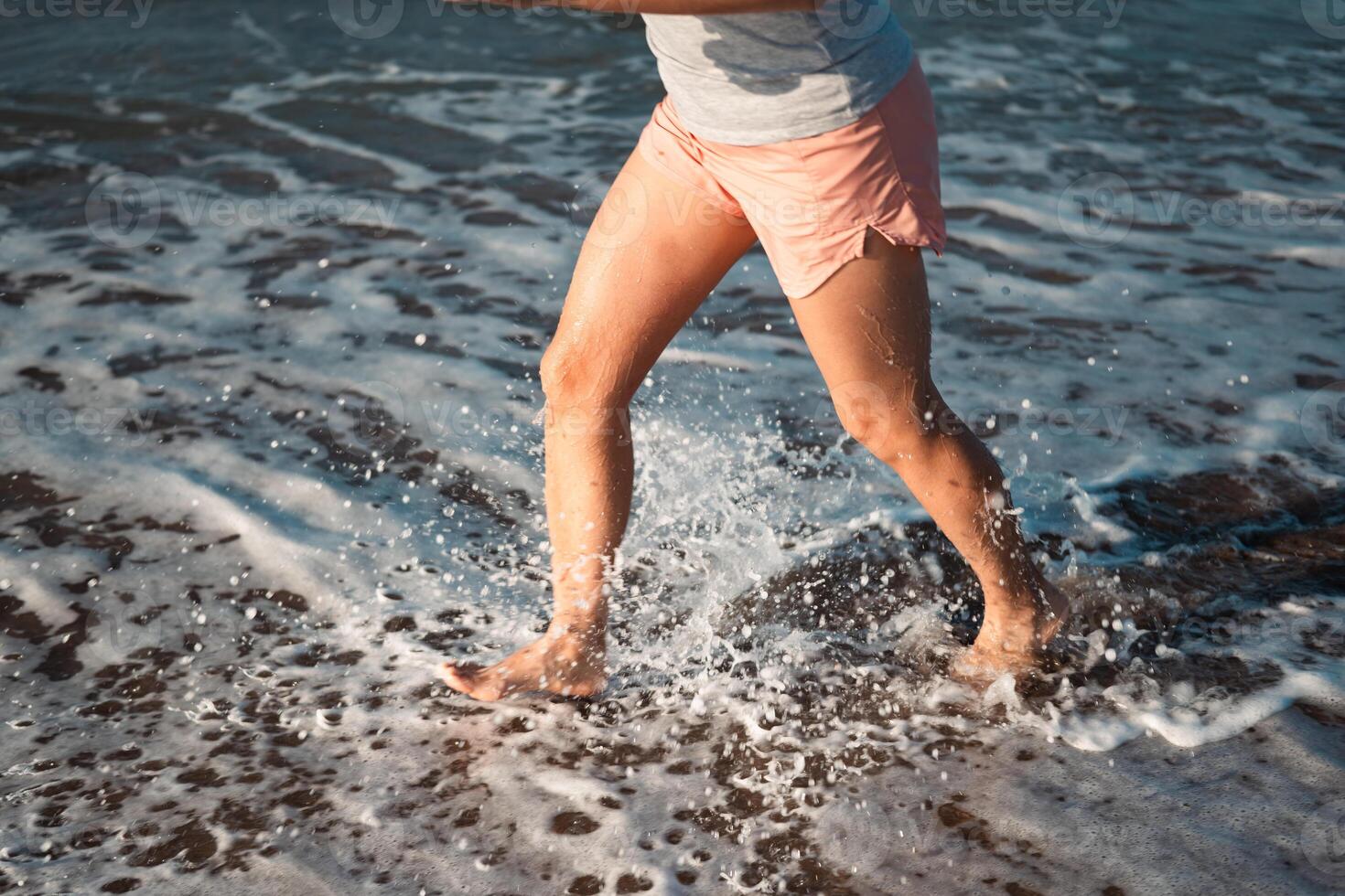 Feet of a runner training on the beach collide with the waves of the Mediterranean Sea. photo