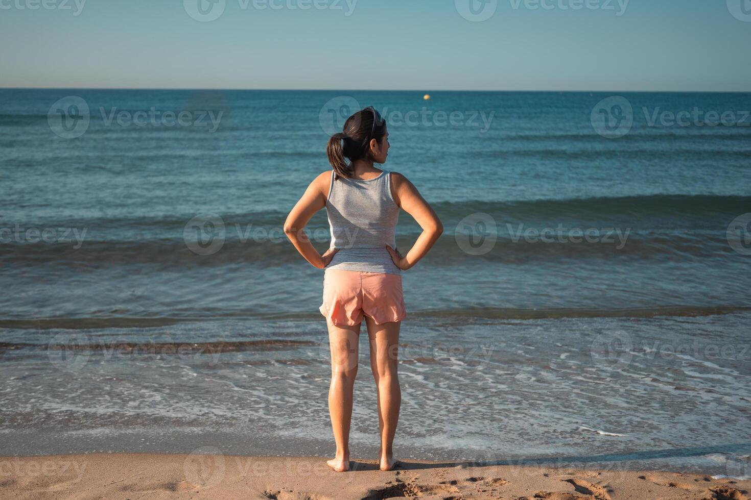 A runner takes a break from her training to contemplate the Mediterranean Sea in the morning. photo