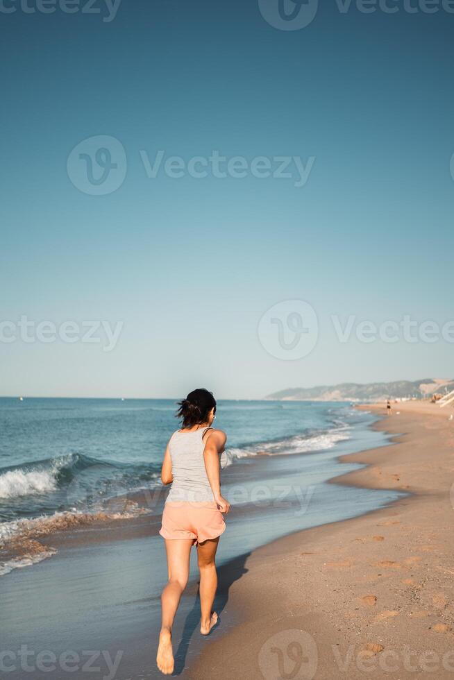 Energetic female runner training on the beach, capturing the essence of health and vitality. photo