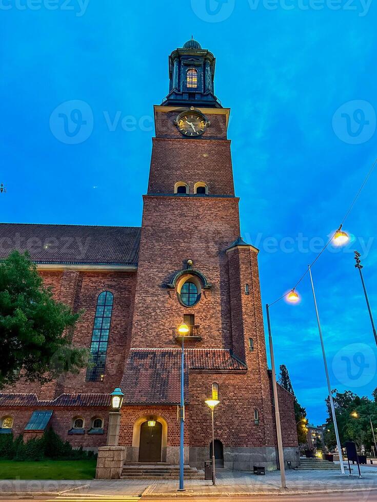 A clock tower in front of a brick building of Eskilstuna in Sweden. photo