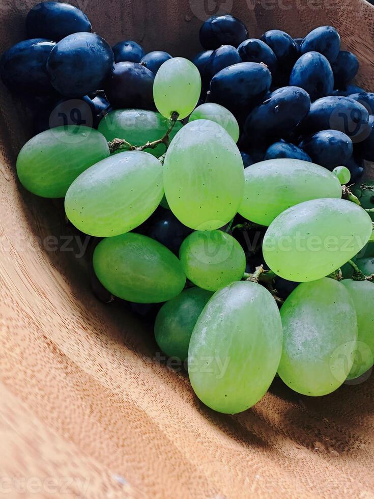 A bunch of grapes sitting on a table. Fruit on a plate. photo