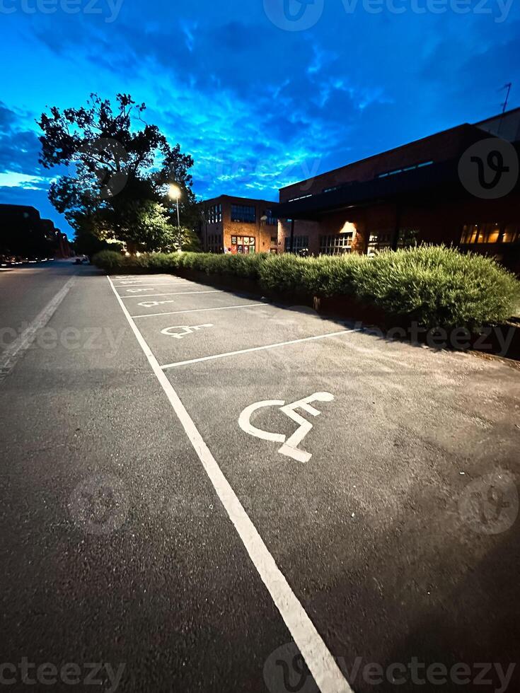 Empty car parking lot at a supermarket with family and disability parking places, public parking road signs photo