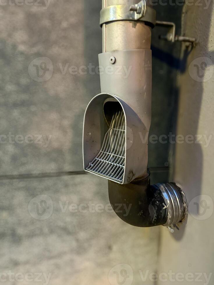 Water drains from the drain pipe into a metal container photo