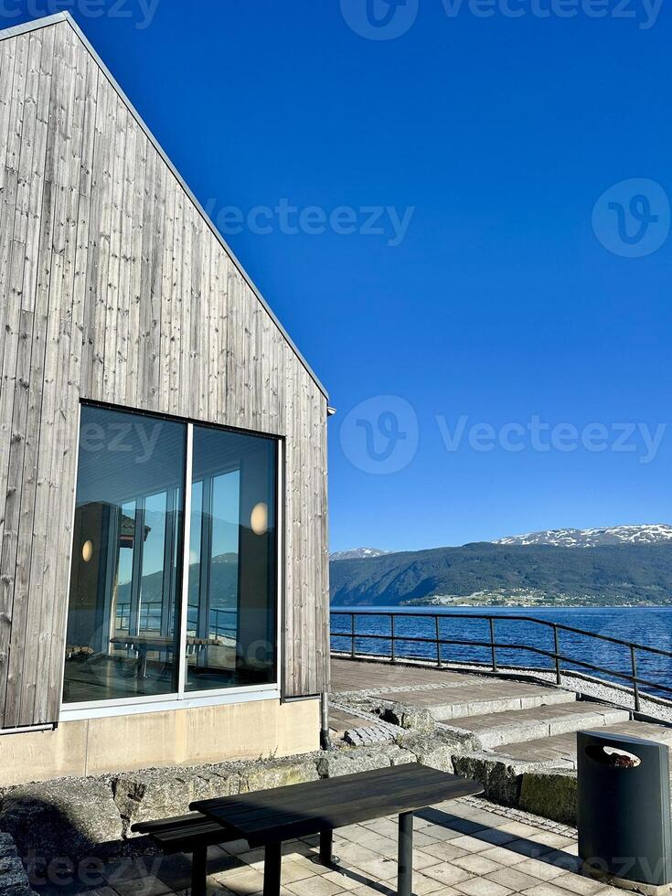 Waiting area for ferry passengers in Sognfjord, Norway. A building with a large window offering a view of a water expanse photo