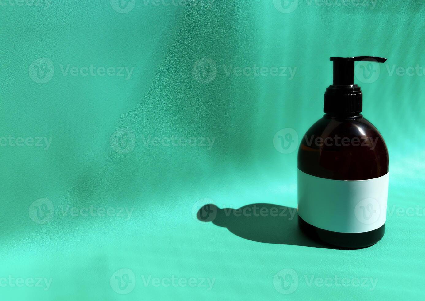 Blank brown glass bottle mock-up with pump isolated on turquoise background. Dark amber glass package. healthcare mock-up template. photo