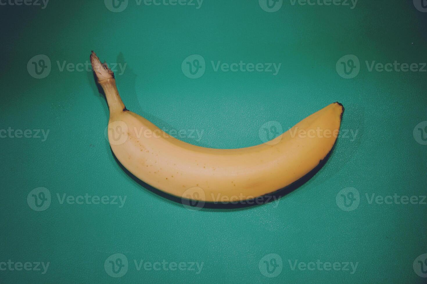 Colorful fruit banana pattern of fresh yellow bananas on blue green background. Vintage style. From top view photo