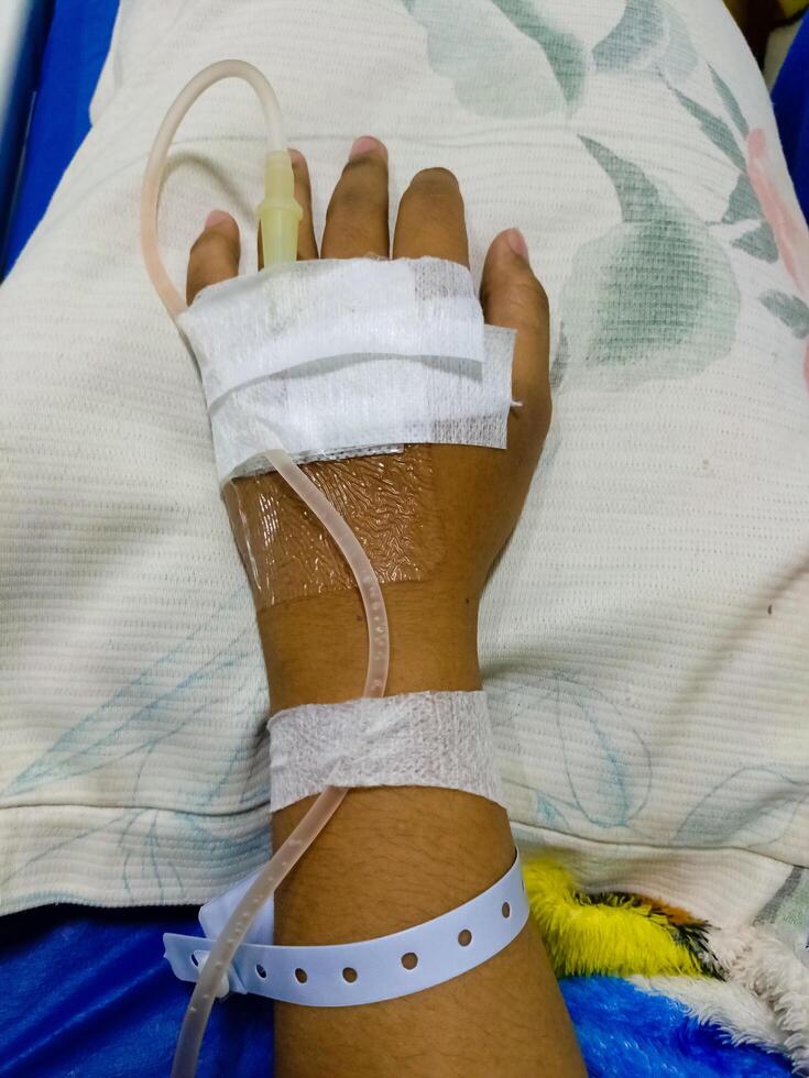 Asian man in hospital with intravenous saline. hand is being infused, infected with the virus, are lying and being treated in beds in hospitals. photo