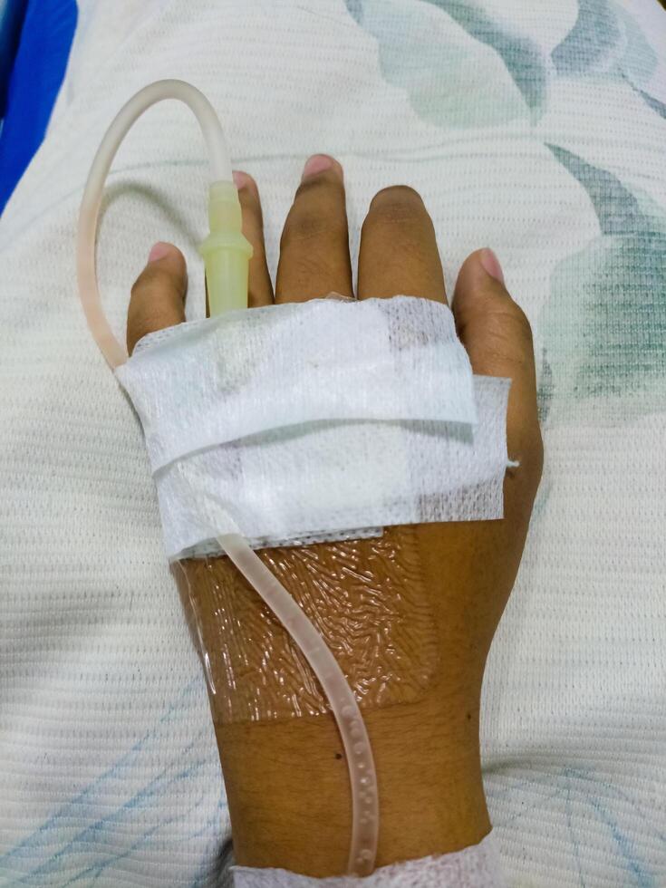 Asian man in hospital with intravenous saline. hand is being infused, infected with the virus, are lying and being treated in beds in hospitals. photo