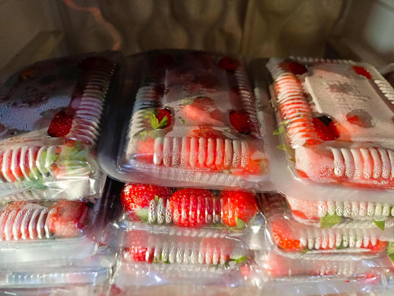 Strawberries from local market, Fresh strawberries picked from home garden in a tray, Red ripe strawberries in plastic tray and packed in clear plastic bag for sale photo